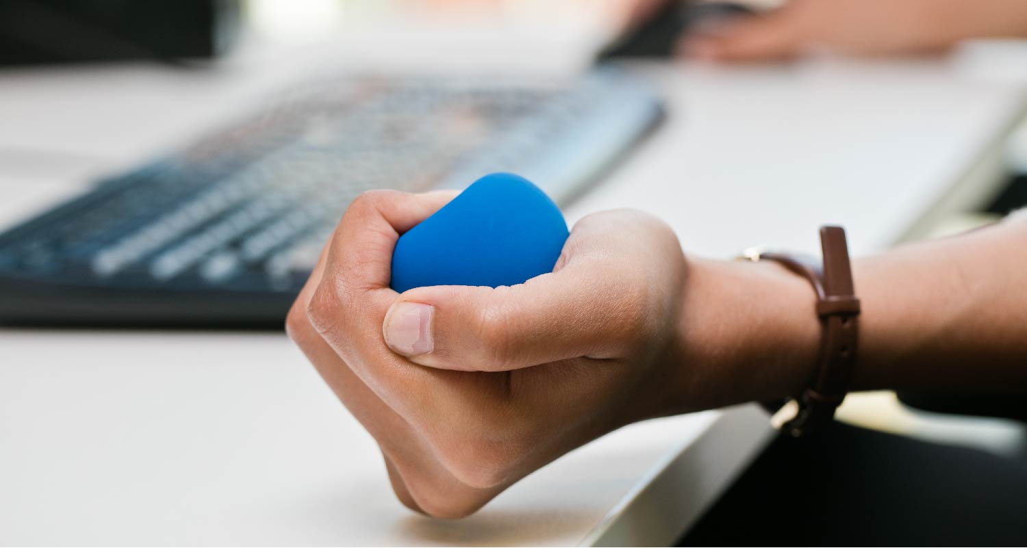 A hand squeezing a stress ball