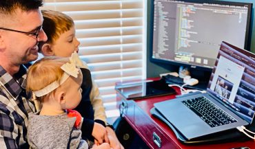 Josh at his computer with kiddos on his lap