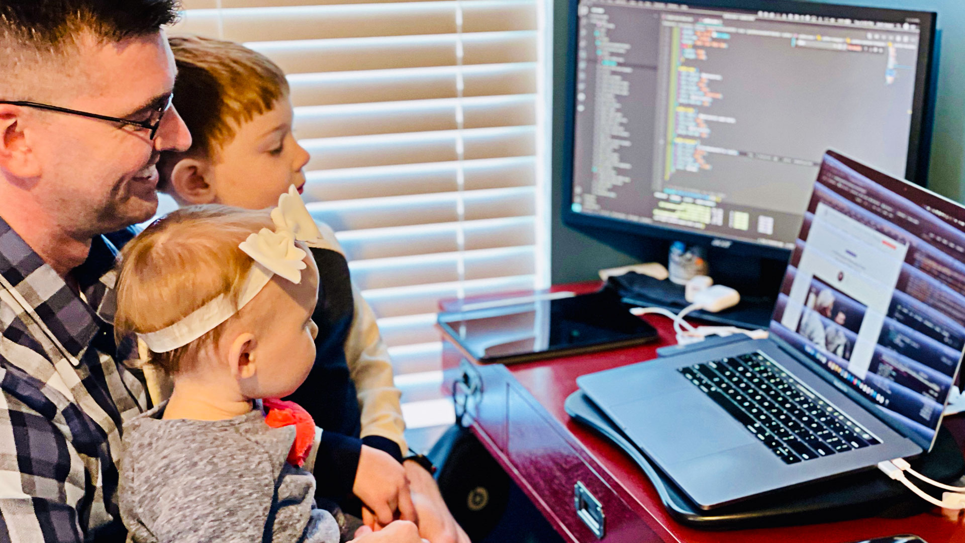 Josh at his computer with kiddos on his lap