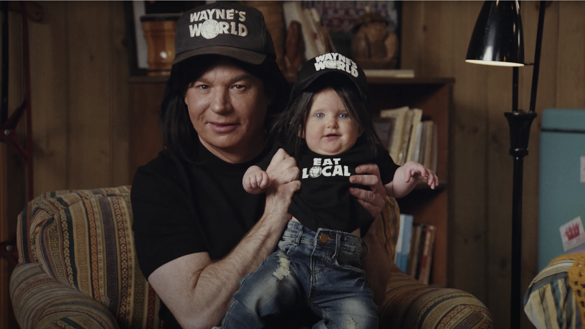 Wayne of Wayne's World holding a baby in Uber Eats Super Bowl commercial